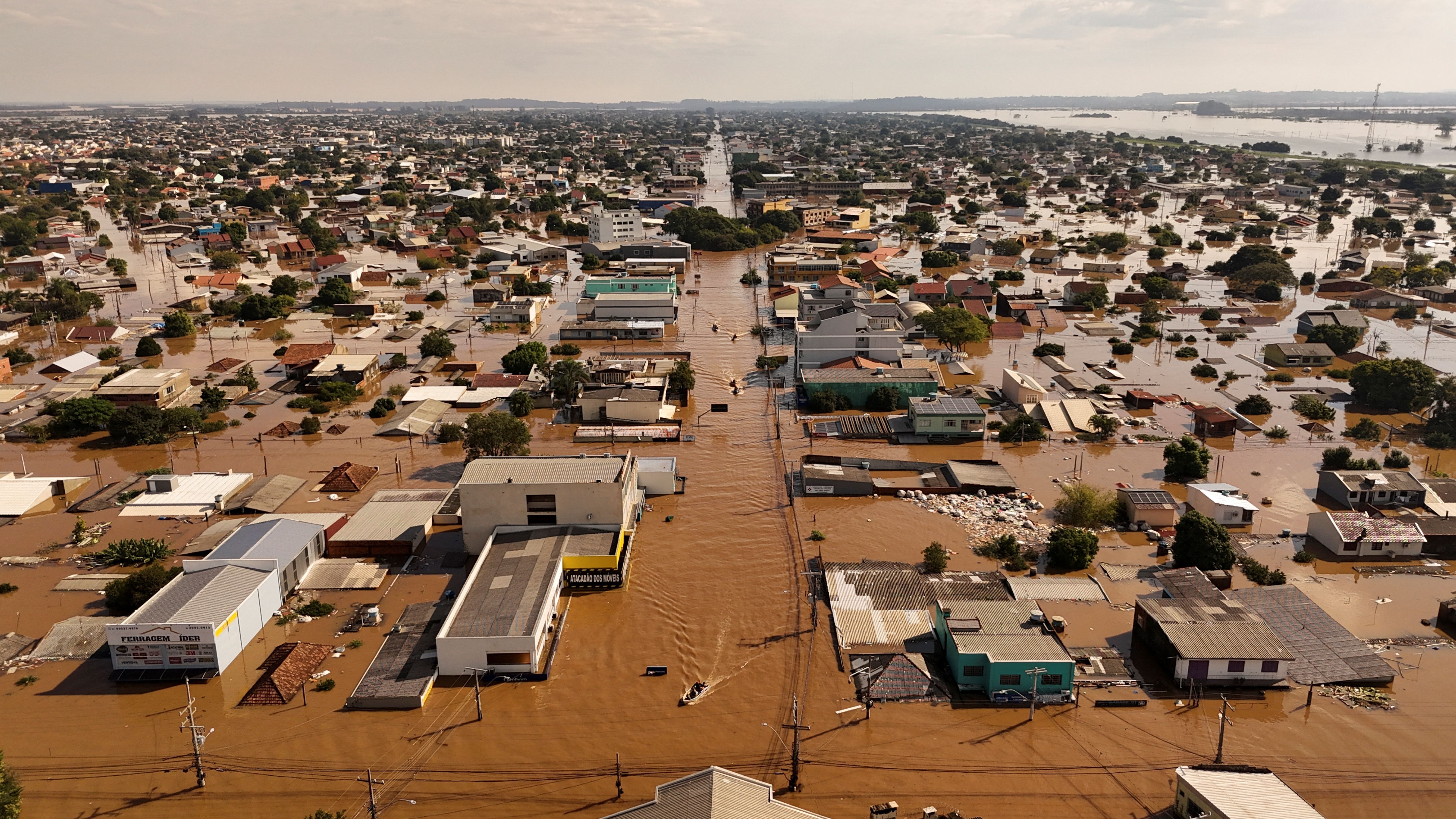 Vista aérea de pessoas em botes buscando por pessoas isoladas em meio à inundação na cidade de Canoas, no Rio Grande do Sul