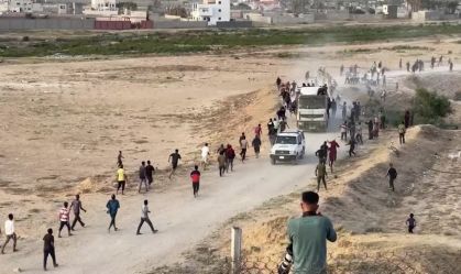 Palestinos pulam em caminhão em movimento para pegar ajuda