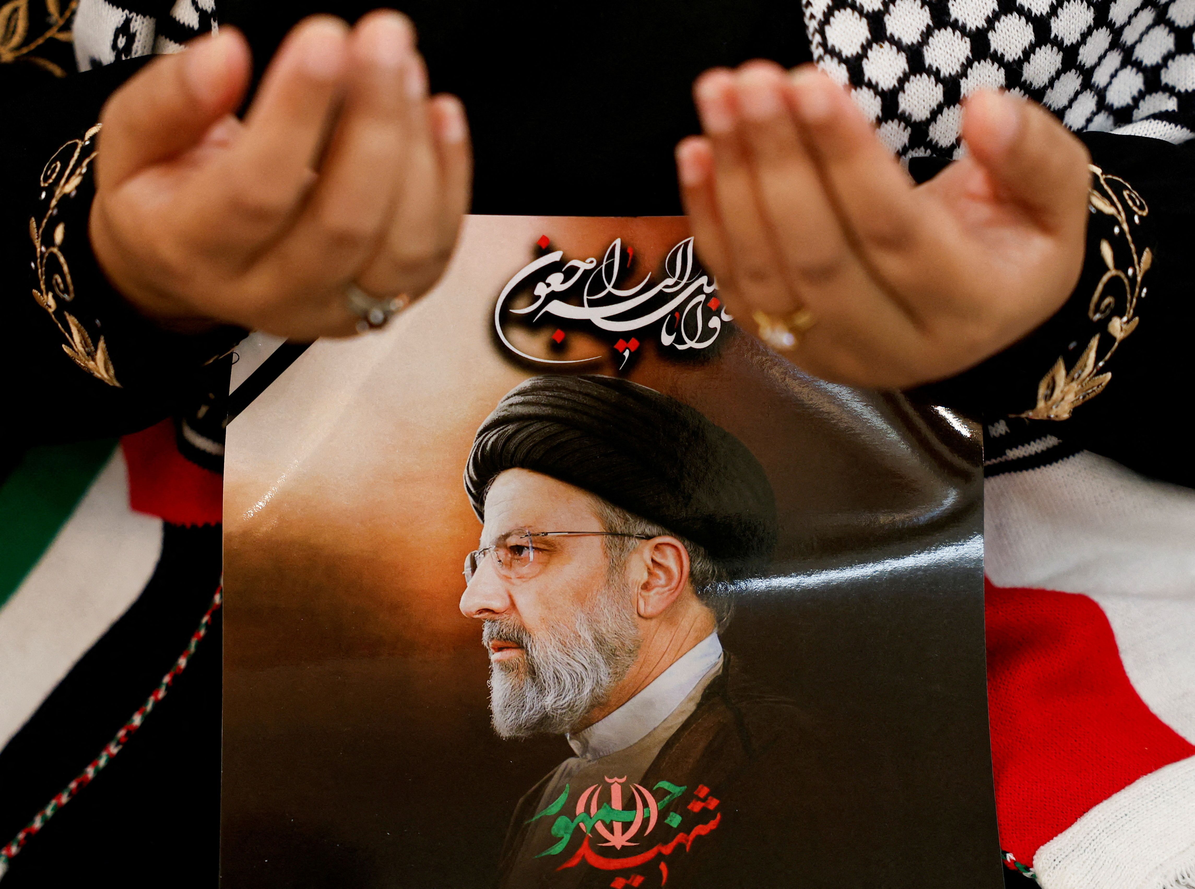 Pessoa em luto segura foto do falecido presidente iraniano Ebrahim Raisi, na residência do embaixador iraniano em Jacarta, Indonésia