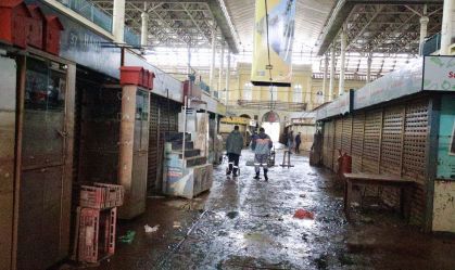 Vista interna do Mercado Público de Porto Alegre (RS) após enchentes; marca na parede mostra altura que a água chegou