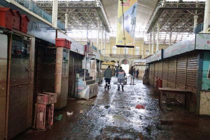 Vista interna do Mercado Público de Porto Alegre (RS) após enchentes; marca na parede mostra altura que a água chegou
