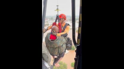 Momento em que a vítima é resgatada de helicóptero por militar da Marinha no Rio Grande do Sul