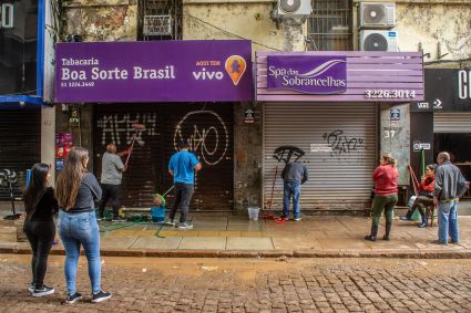 Após queda no nível da água, funcionários fazem a limpeza em comércio na região central de Porto Alegre (RS)