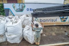 Equipe da prefeitura de Porto Alegre coloca sacos de areia em comportas para conter a água do Guaíba
