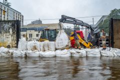 Equipe da prefeitura de Porto Alegre coloca sacos de areia em comportas para conter a água do Guaíba