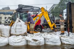 Equipe da prefeitura de Porto Alegre coloca sacos de areia em comportas para conter a água do Guaíba