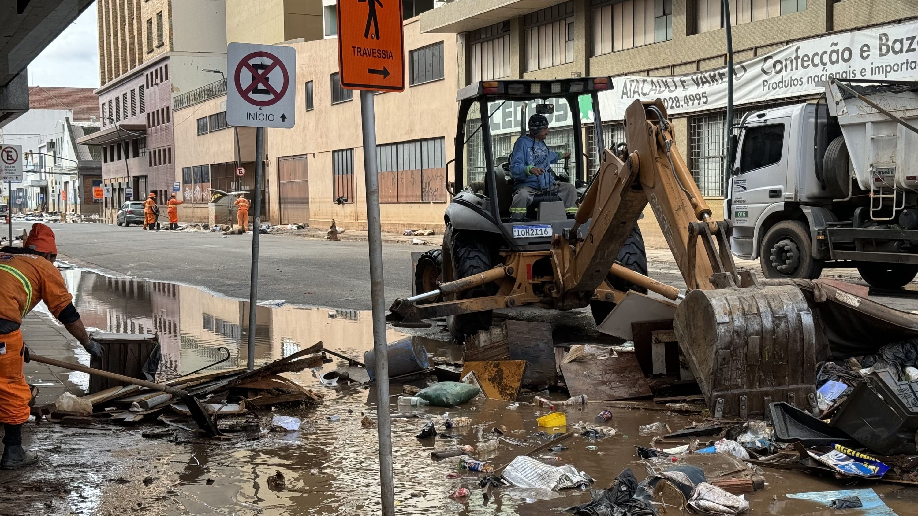 Equipes da prefeitura de Porto Alegre (RS) limpam as ruas após enchente histórica