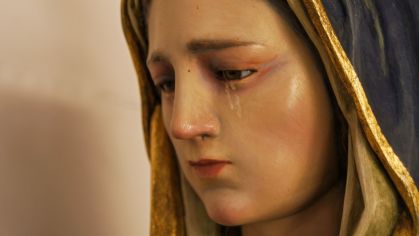 Estátua de Virgem Maria chorando.