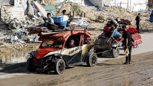 Centenas de palestinos, incluindo mulheres e crianças que vivem na parte leste de Rafah, migram para a parte oeste de Khan Yunis com seus poucos pertences carregados em veículos após o anúncio de Israel sobre a evacuação de bairros