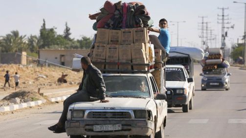 Centenas de palestinos, incluindo mulheres e crianças que vivem na parte leste de Rafah, migram para a parte oeste de Khan Yunis com seus poucos pertences carregados em veículos após o anúncio de Israel sobre a evacuação de bairros