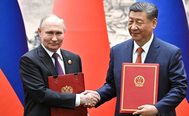 Presidente russo Vladimir Putin e o líder chinês Xi Jinping trocam documentos durante cerimônia em Pequim, China, em 16 de maio de 2024. / Kremlin Press Office / Handout/Anadolu via Getty Images