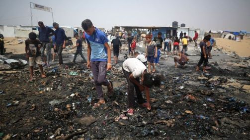 Palestinos se reúnem no local de um ataque israelense a um campo para deslocados internos em Rafah, em 27 de maio de 2024