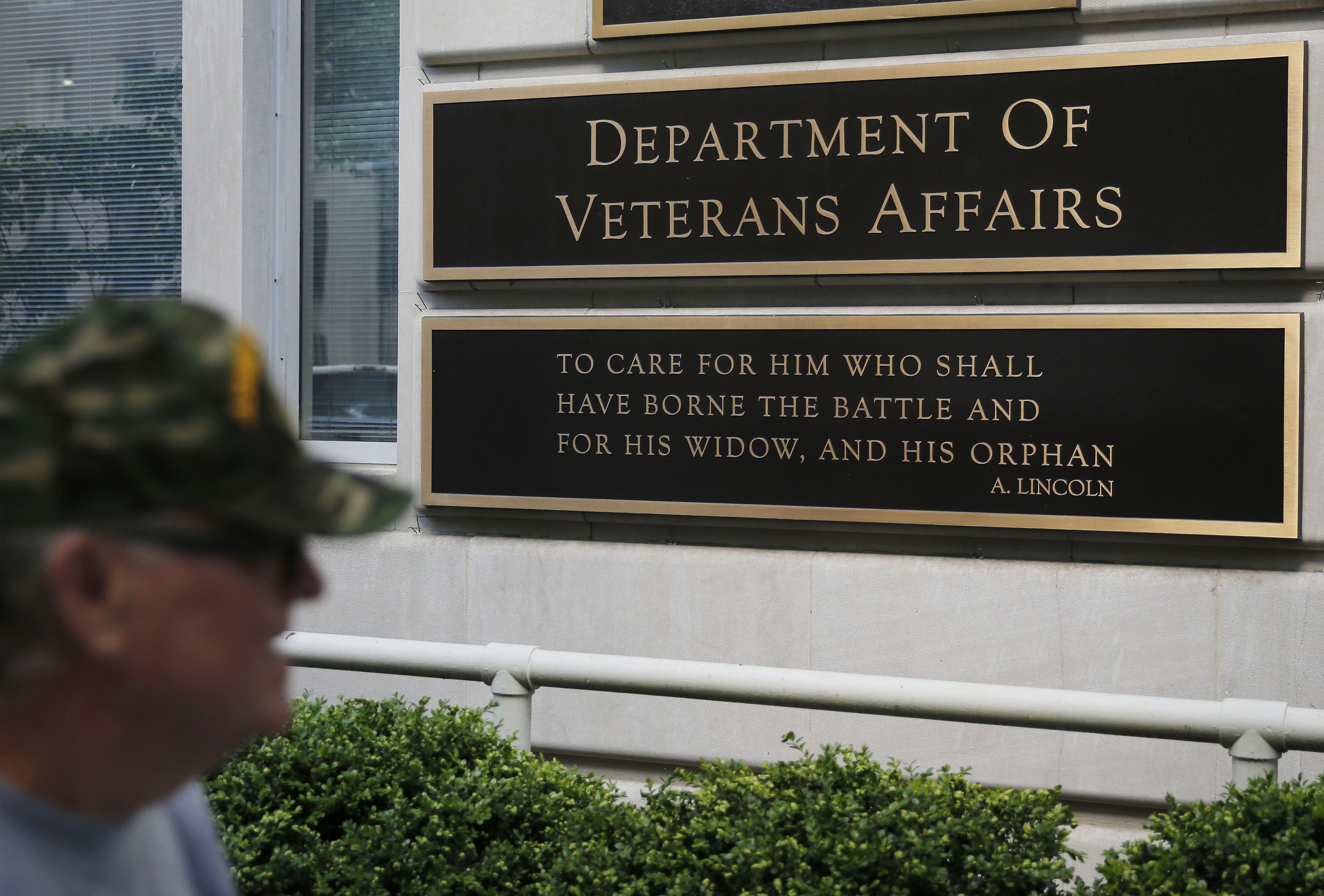 The sign in the front of the headquarters building at the Department of Veteran Affairs is seen as a man walks past in Washington