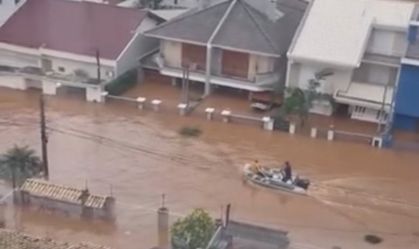 Moradores da cidade de Canoas (RS) se locomovem com jet ski pelas ruas alagadas