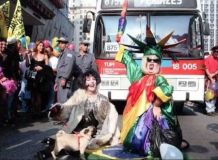 Drag Queen Kaka Di Polly enrolada em bandeira do orgulho LGBT+ na avenida Paulista