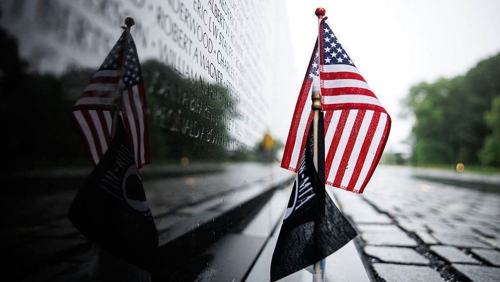 Bandeira dos Estados Unidos é colocada na base dos nomes gravados no granito preto do Memorial dos Veteranos do Vietnã, no Dia da Memória (Memorial DAy), em 25 de maio de 2026, em Washington, DC