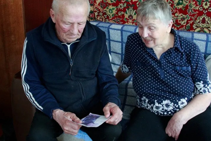 Halyna e Vasyl Khyliuk olham para uma foto de seu filho, prisioneiro da Rússia, em sua casa em Kozarovychi, Ucrânia / Ivana Kottasova/CNN