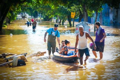 Pessoas caminham pelas ruas inundadas enquanto os esforços de resgate continuam no bairro Menino Deus em 7 de maio de 2024 em Porto Alegre, Brasil.