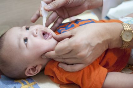 Bebê recebendo vacina contra poliomielite via oral (gotinhas)