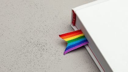Livro com marcador de página pintado nas cores do arco-íris, assim como a bandeira do Orgulho LGBT+