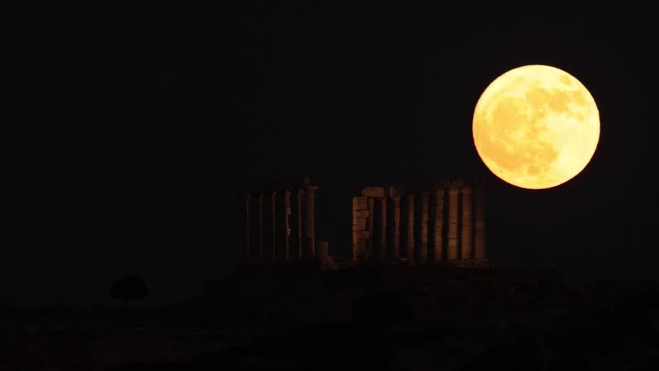 'Strawberry Moon' rises behind ancient Greek temple