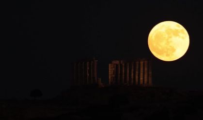 'Strawberry Moon' rises behind ancient Greek temple