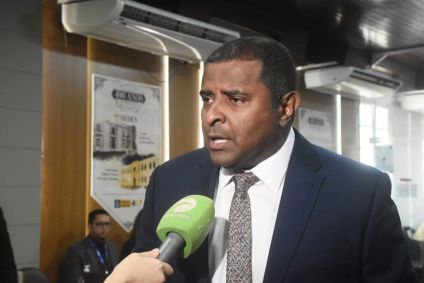 Fábio Câmara é negro, tem cabelo preto, veste terno preto e uma gravata acinzentada