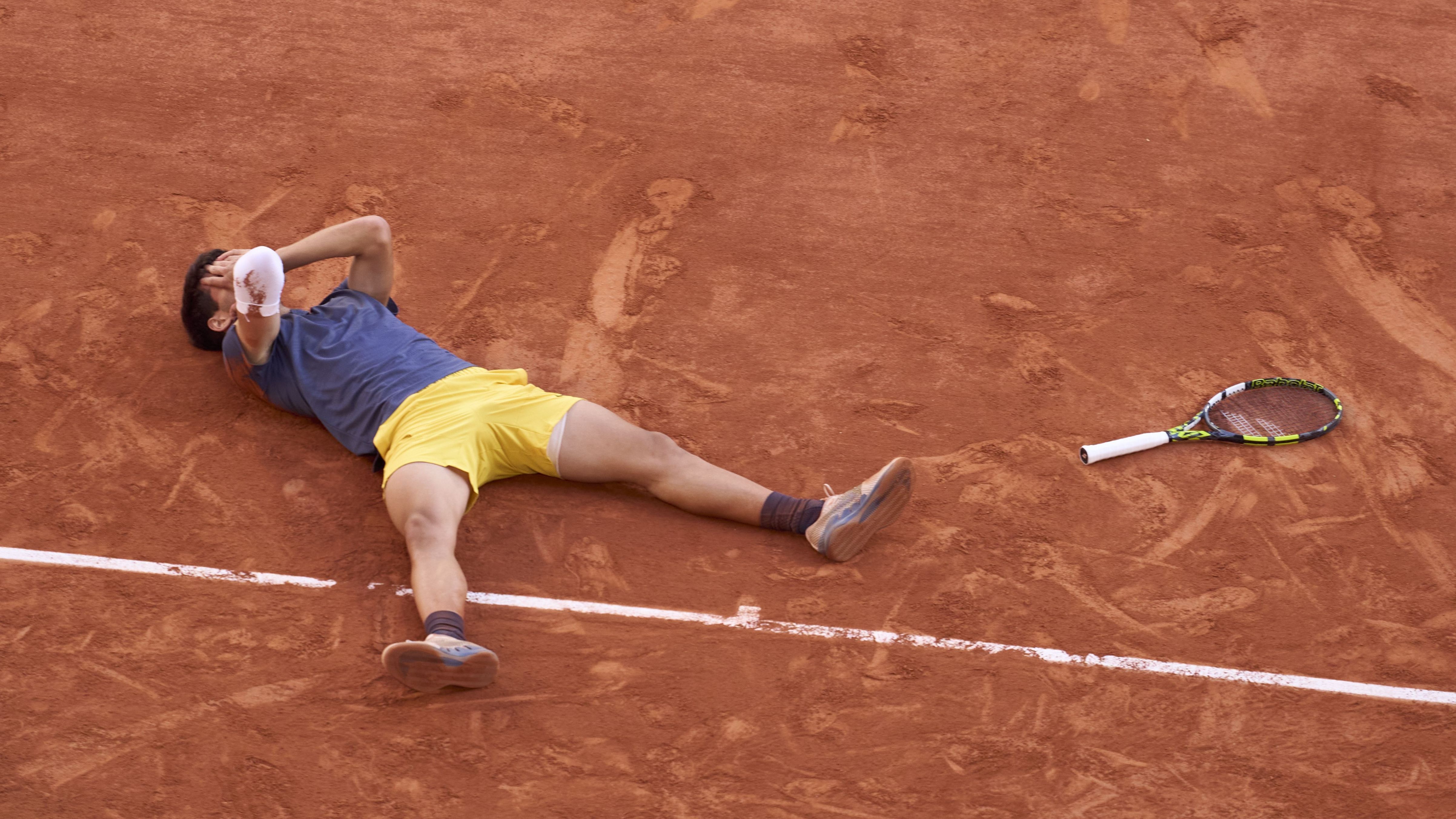 Carlos Alcaraz deita no saibro e comemora o título de Roland Garros