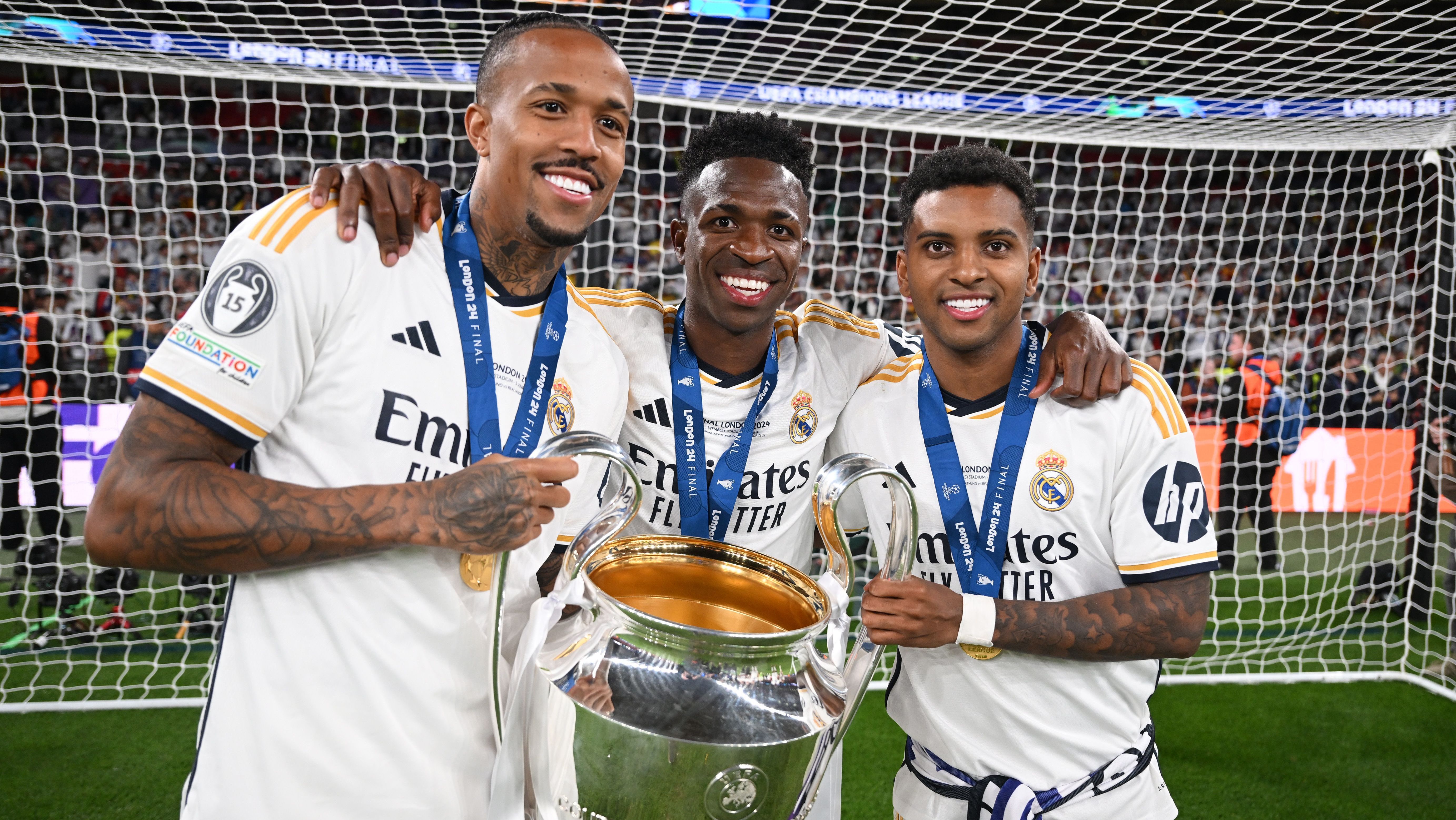 Éder Militão, Vinicius Junior e Rodrygo com o troféu da Champions League
