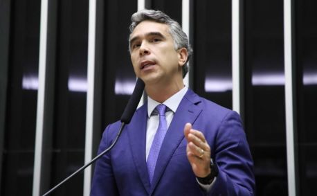 Rafael Brito veste terno azul, gravata azul, é branco e tem cabelo grisalho