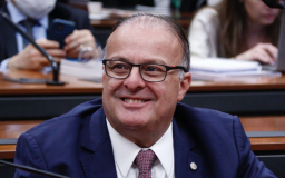 Paulinho Freire é branco, usa óculos, terno azul escuro, camiseta branca e gravata vermelha estampada
