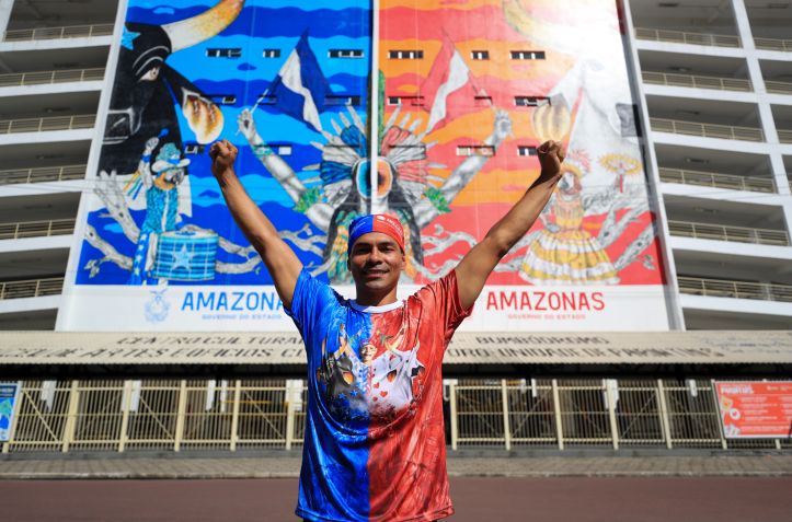 Pito Silva, artista parintinense responsável pelo novo mural do Bumbódromo. Ao fundo, como era o mural antigo. / Alex Pazuello/Secom AM