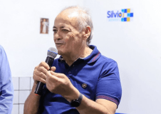 Silvio Mendes (União Brasil) é idoso, calvo, branco, segura um microfone e veste camisa polo azul com detalhes vermelhos.