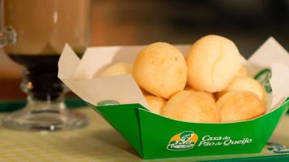 Pães de queijo em cesta com logo da Casa do Pão de Queijo