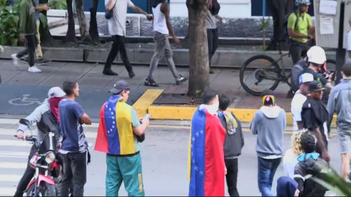 Pessoas com bandeira da Venezuela protestam após Nicolás Maduro ser declarado vencedor das eleições presidenciais
