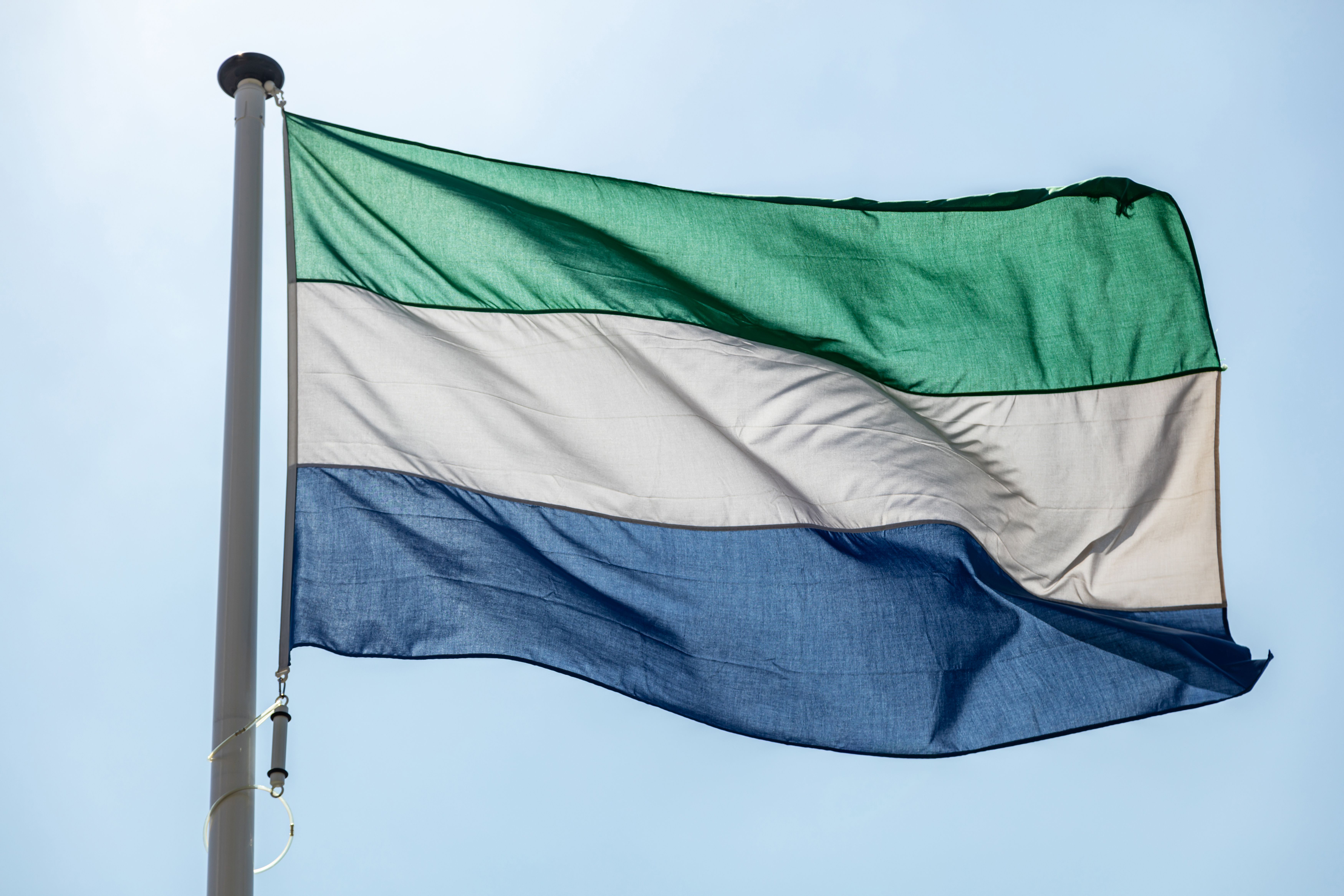 Sierra Leone flag waving against clear blue sky