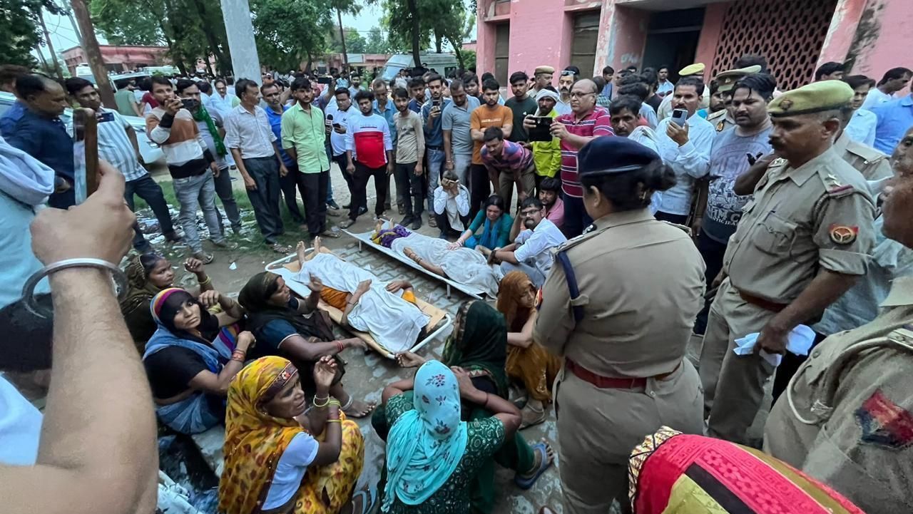 Parentes daqueles que foram feridos ou morreram durante uma debandada em um evento religioso, ''Satsang'', no distrito de Hathras, na Índia, se reúnem em volta de dois corpos
