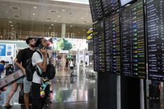 Passageiros olham para uma tela que exibe voos atrasados em meio a falha cibernética global ​​no Aeroporto de Barcelona em 19 de julho de 2024 em Barcelona, ​​​​Espanha.