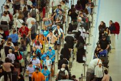 Filas de passageiros esperam na fila no Aeroporto de Suvarnabhumi observando os aviões atracados enquanto uma falha cibernética global causada por uma interrupção da Microsoft e um problema de TI da CrowdStrike se combinam para afetar os usuários