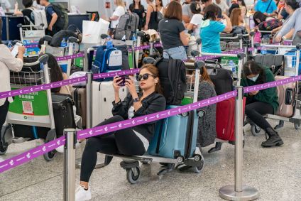 Viajantes fazem fila nos balcões de check-in do Aeroporto Internacional de Hong Kong em 19 de julho de 2024 em Hong Kong, China.