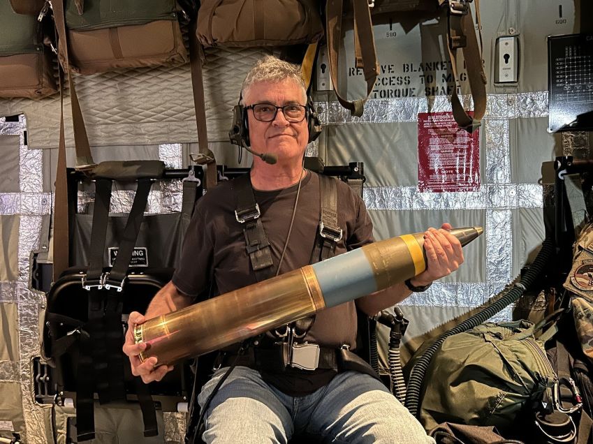 O redator sênior de assuntos militares globais da CNN, Brad Lendon, segura um obus de 105 mm a bordo de um caça AC-130J da Força Aérea dos EUA voando da Base Aérea de Osan, Coreia do Sul, em junho de 2024 / Mike Valerio/CNN via CNN Newsource