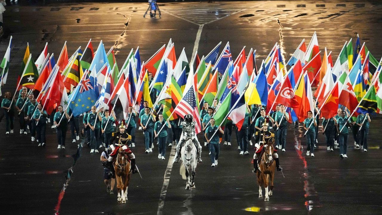 Bandeira olímpica sendo carregada até a praça Trocadéro