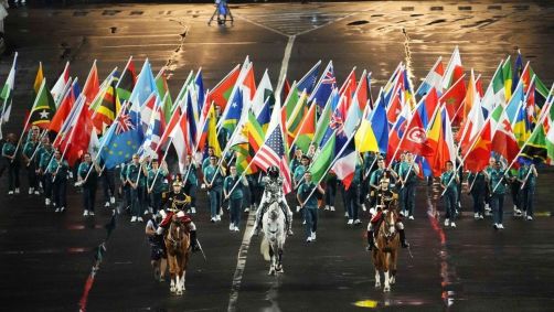 Bandeira olímpica sendo carregada até a praça Trocadéro
