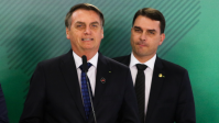 Flávio retorna ao Brasil sob críticas por ausência durante crise do pai