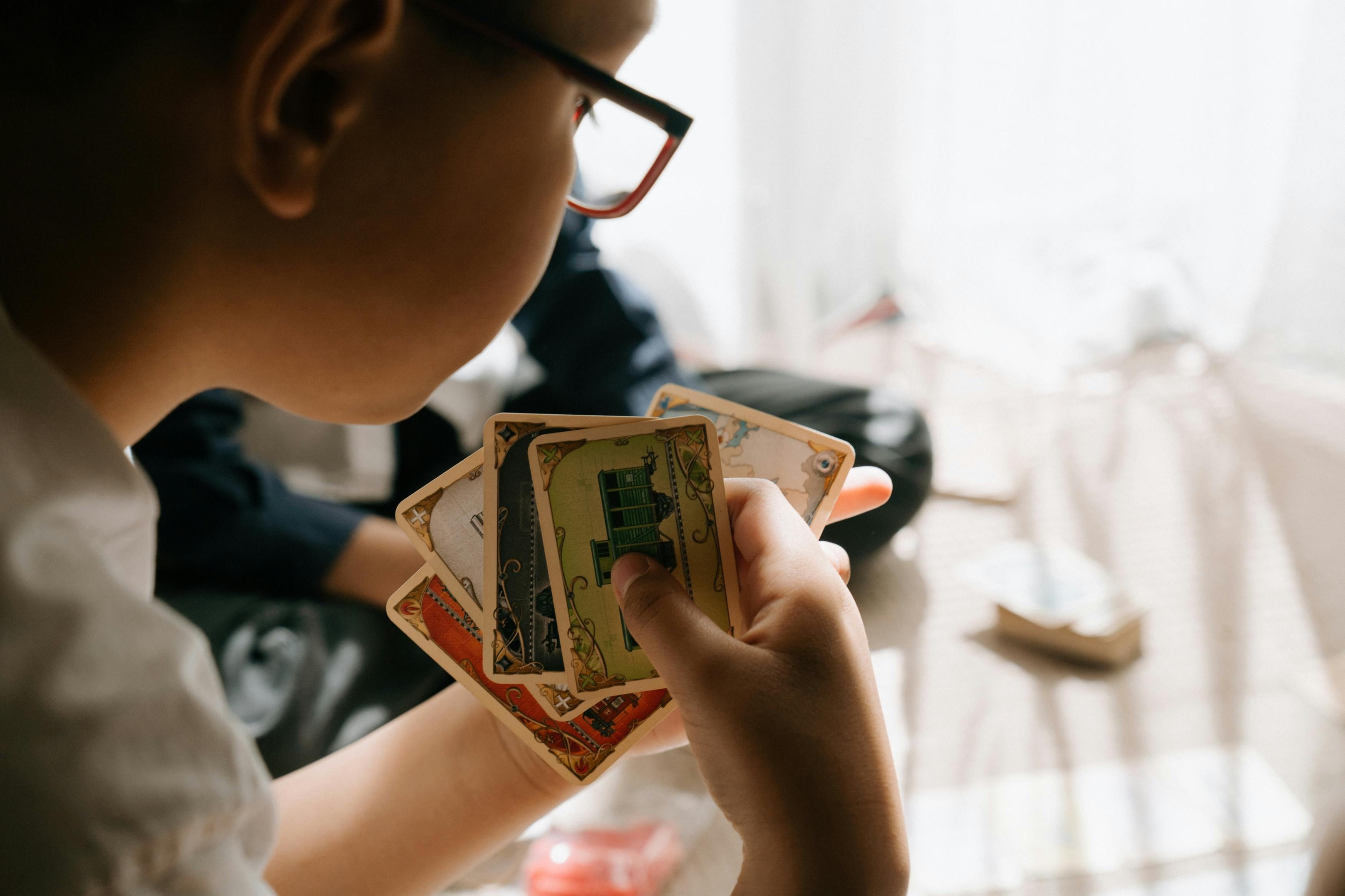 Menino observa situação durante jogo de cartas