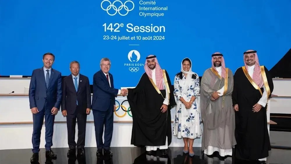 Thomas Bach aperta mão de Abdulaziz bin Turki Al Faisal, ministro dos Esportes e presidente do Comitê Olímpico e Paralímpico Saudita, após 142ª reunião do COI