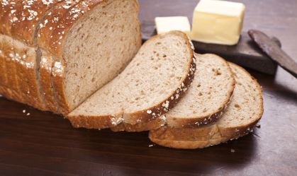 sliced loaf of multi-grain oat bread with butter