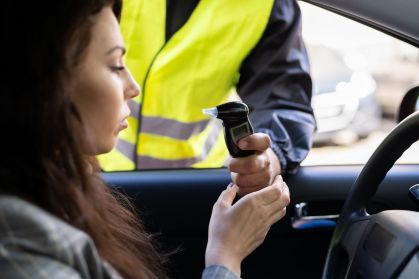 Policial fazendo teste do bafômetro em mulher
