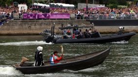 Tocha olímpica é transportada em um barco ao longo do rio Sena na cerimônia de abertura