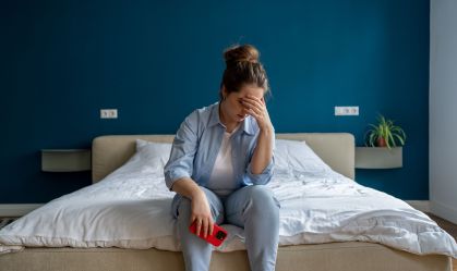 Woman with breaking heart crying holding phone after reading breakdown of relations message.
